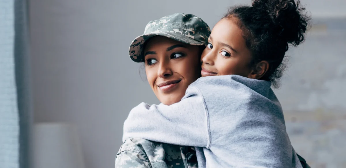 Military mother hugging her duaghter